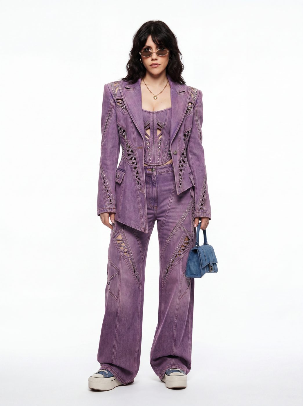 A lilac tailored suit with a distressed finish, worn with a small denim bag