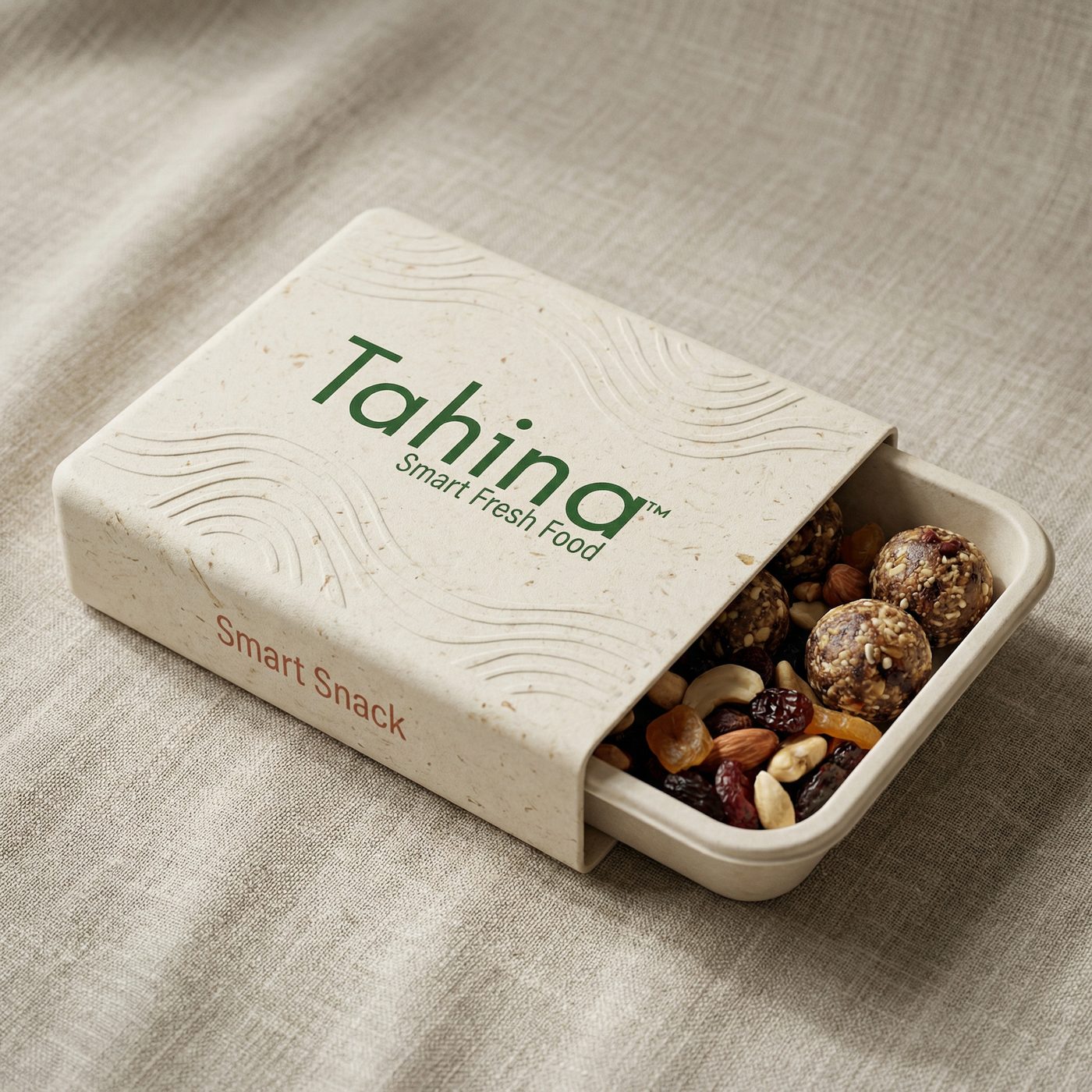A Tahina Smart Snack box on linen, opened to show nuts and seeds inside